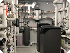 A Room Filled With Various Industrial Pipes, Valves, And Machinery In An Organized Layout.