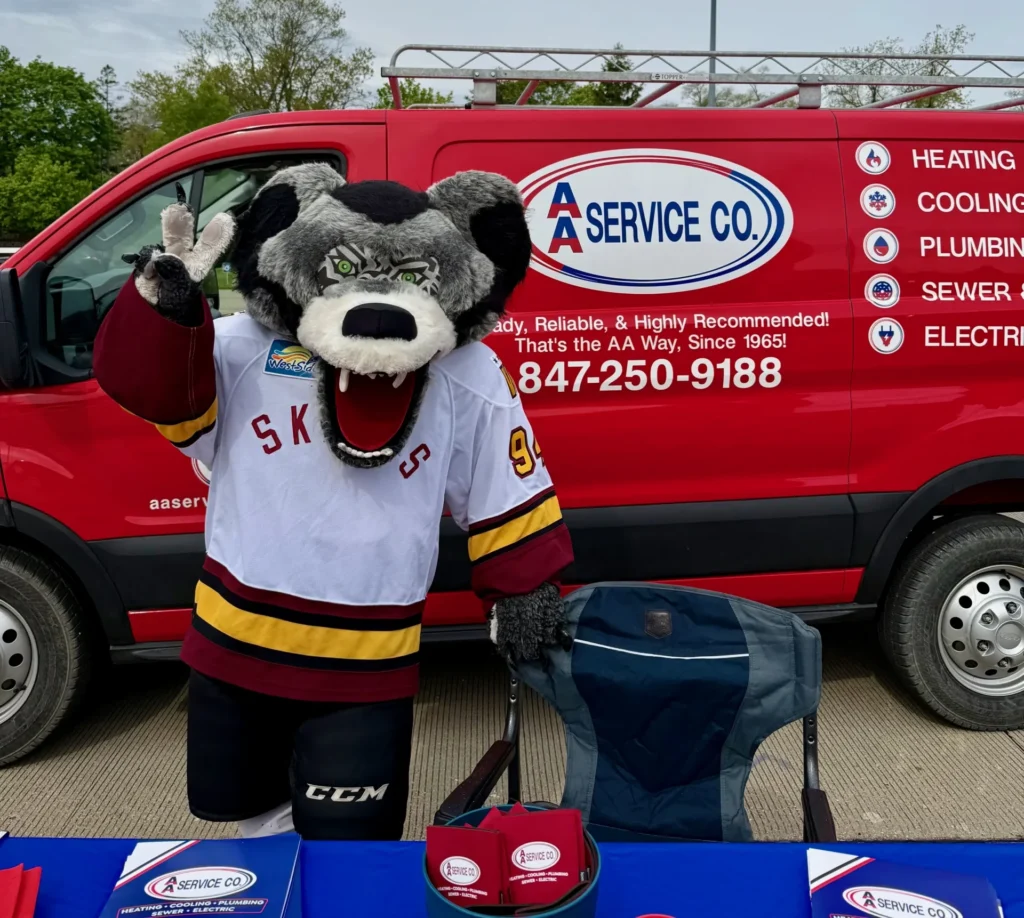 A Hockey Team Mascot In A White Jersey Waving In Front Of A Red Aa Service Co. Utility Van.